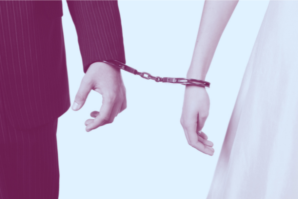 Bride & groom handcuffed together, representing the harms of forced and child marriage.