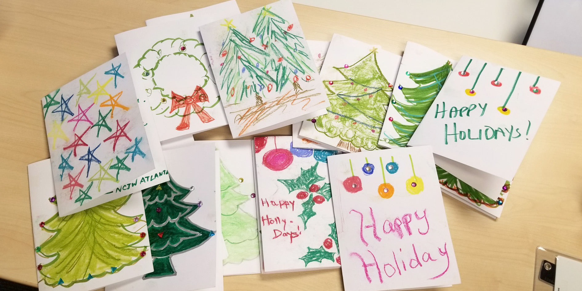 Colorful collection of handmade holiday cards created by volunteers for Tahirih clients