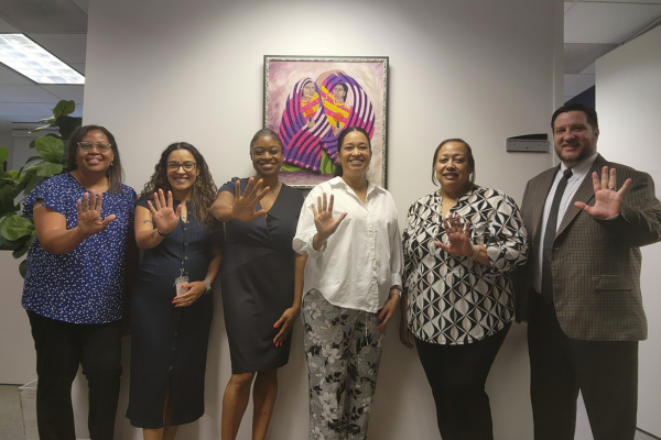 Staff of Tahirih Atlanta office holding up five fingers for five years.